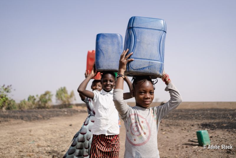 Westafrikanische Mädchen beim Wassertransport