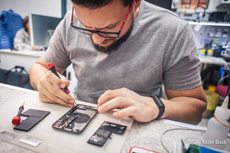 Mann repariert Handy